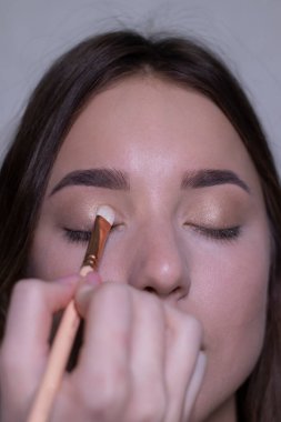 Güzel bir esmerin makyajını yapma süreci. güzellik, modellik ve kozmetik konsepti