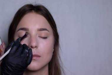 Siyah eldivenli bir usta tarafından güzel bir esmere makyaj yapma süreci. güzellik, modellik ve kozmetik konsepti