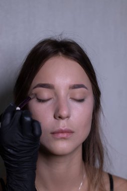 Siyah eldivenli bir usta tarafından güzel bir esmere makyaj yapma süreci. güzellik, modellik ve kozmetik konsepti