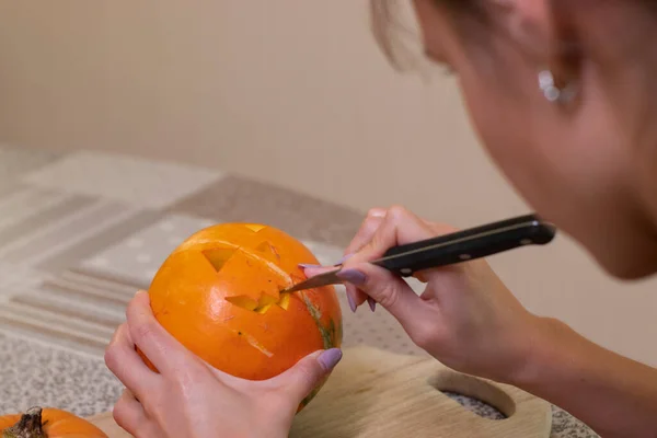 Le processus de fabrication d'une citrouille d'Halloween. couper la bouche par une fille brune. thème de l'horreur et Halloween — Photo
