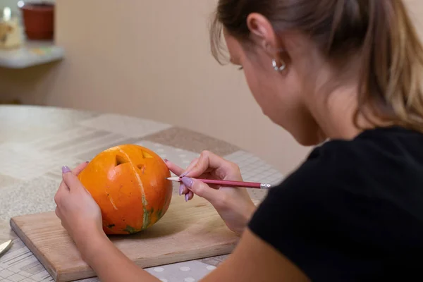 Processen för att göra en Halloween pumpa. Teckna en layout av en brunett flicka. skräcktema och halloween — Stockfoto