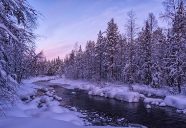 Kış güzel gün batımı, Sigara donmuş nehir ve orman karla kaplı, Lapland yatay çarpıcı. Nehir, el değmemiş beyaz kar. Fantastik buz ve frost doğal dekor su üzerinde dallar.