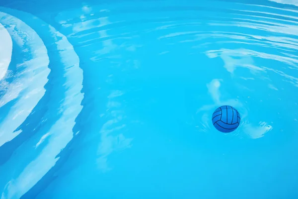 Child\'s blue ball, circles and air bubbles on water surface in pool.  Stairs are visible through clean water. Reflected sky and surroundings. Summer atmosphere and private safety on water concepts.