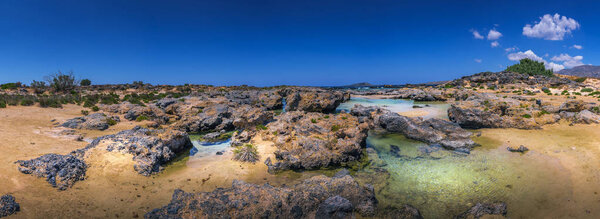 Panoramic beautiful landscape of Crete island, Greece, Europe. Mediterranean seaside with golden sand beach, rock formation and turquoise green clean and transparent water. Greeting card background.