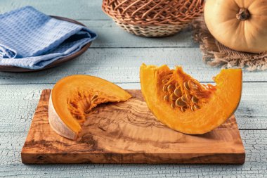 Zeytin ağacı kesme tahtasıüzerinde iki kabak dilimi