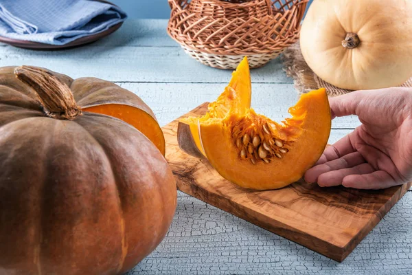 Tomar rodajas de calabaza fresca con semillas a mano — Foto de Stock