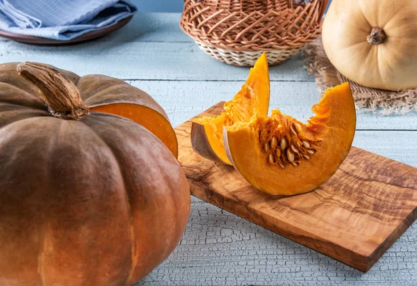 Calabaza naranja y sus rebanadas en tabla de cortar — Foto de Stock