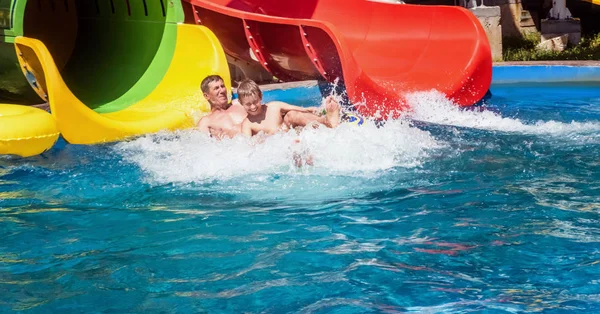Lycklig familj njuter av vattenpark Slide — Stockfoto