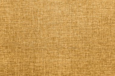 Empty abstract background with natural burlap detailed texture. Ecology friendly rough fabric threads toned in honey dijon mustard color. Copy space. Surface from directly above view.