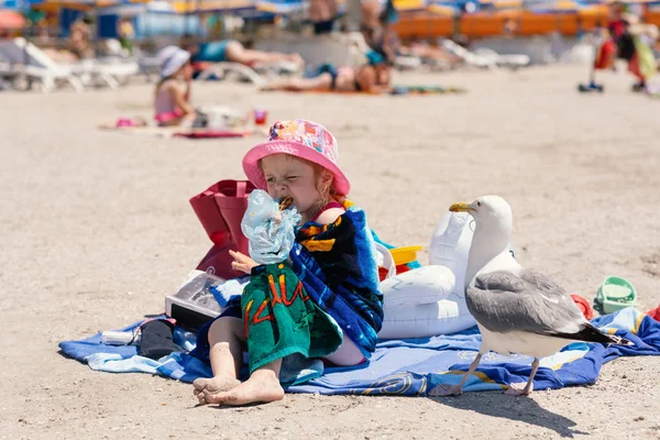 Küçük Kız Sahilde Havlu Oturur Bal Baklava Yiyor Martı Eylem — Stok fotoğraf