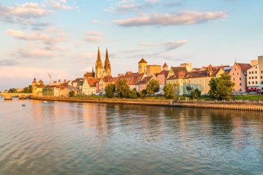 Regensburg şehir, Almanya. Tuna Nehri, Regensburg Katedrali ve taş köprü arka plan, günbatımı'dan göster