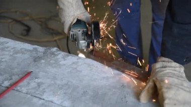 Kesme dikdörtgen metal profil kullanarak elektrik açı değirmeni, uzman becerileri işlemidir. İş süreci portre. Metal inşaat kaynak için parçalar hazırlanması
