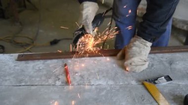 Elektrik açı değirmeni, beceri ve yetenek kullanarak uzman kesme dikdörtgen metal profil sinek çevresinde, işlem closeup kıvılcım