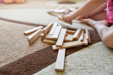 Küçük beyaz kız halı üzerinde oturup oynamak oyun, geliştirme oyuncaklar, işlem