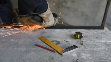 Uzmanı, iş, metal elektrik Açı Öğütücü ile kesti. Yalancı çalışma araçları boyunca: kalem, mezura ve deneyin kare