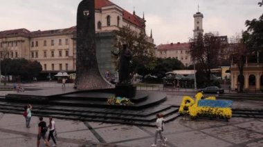 Lviv, Ukrayna - 25 Ağustos 2018: yürüyüş insanlar ve fotoğraf heykel Taras Şevçenko yakınındaki yapmak. Belediye Binası ve şehir merkezine bakan kadar uçan
