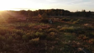 Sonbahar akşam, doğanın, lens flare doğal etkisi güzelliği harika gün batımı. Çayır ortasında ahşap kulübe