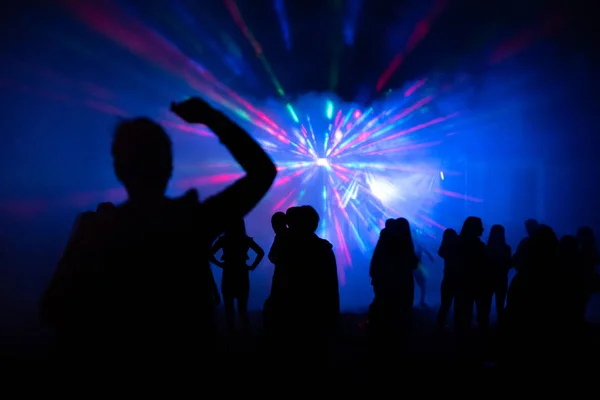 Abstract blurry background, silhouettes of people at open air party, nightlife