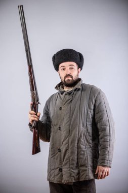 Avcı yatay double-barreled tüfekle elinde, tüfek ileri yönlendirilmiş, retro tarzı, stüdyo çekim olduğunu.