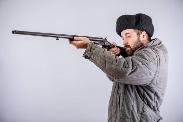 Hunter took the target, horizontal double-barreled shotgun in hands, studio shot