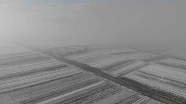 フィールドの空撮は、雪と道路の近くの古い墓地で覆われています。冬が来た. — ストック動画