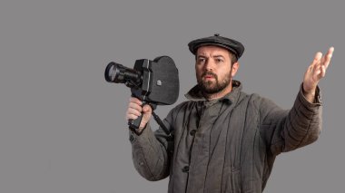 Duygusal kameraman retro kamera stüdyo vurdu onun elinde. Eski moda giyim tarzı. Komik bak. Fikir - 70 film