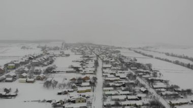 Ukraynalı köyünün havadan görünümü. Karlı kış günü. Yumuşak bir uçuş geri