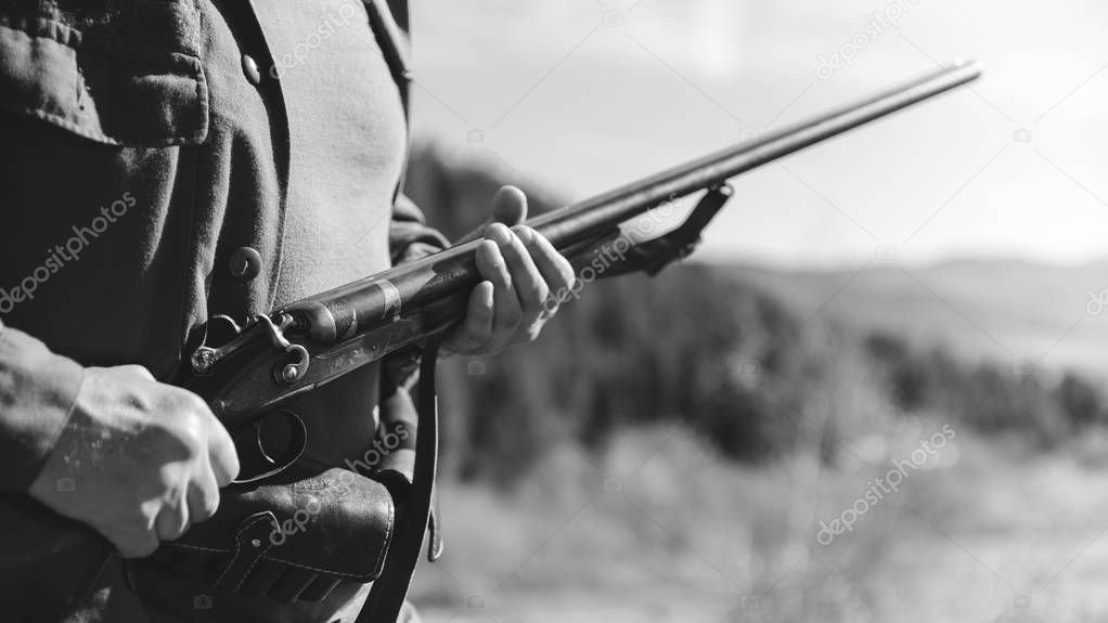 Hunter with horizontal double-barreled shotgun on hunting in the mountains