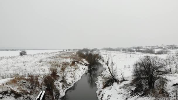 Sul fiume, durante l'inverno. Il terreno è coperto di neve. L'Europa. Tecnica del volo liscio verso il basso — Video Stock