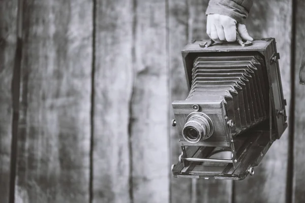 Ретро-камера большого формата, 5х7 дюймов. Фотограф держит старый студийный фотоаппарат. Монохромный эффект, скопировать пространство. Концепция - фотография 1930-1950-х годов — стоковое фото