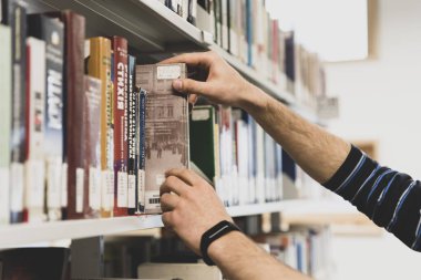 Lviv, Ukrayna-28 Mart 2019: öğrenci Ukrayna Katolik Üniversitesi kütüphanesinde bir kitap arayın. Eğitim teması