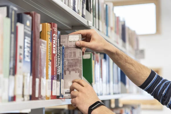 Lviv, Ukrayna-28 Mart 2019: öğrenci Ukrayna Katolik Üniversitesi kütüphanesinde bir kitap arayın. Eğitim teması