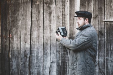 Elinde retro kamera ile eski moda kameraman, mat etkisi. Fikir - sinema endüstrisi, 70 film