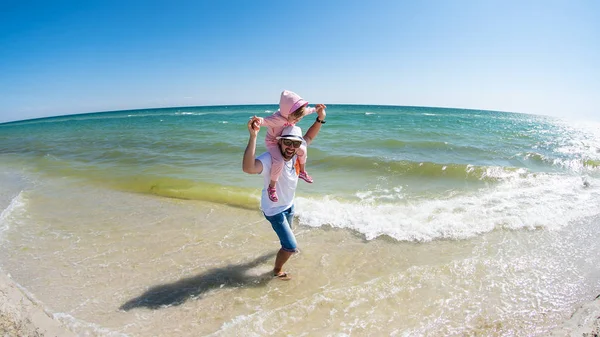 Padre con una hija pequeña se divierten en la playa de arena del Mar Negro. Vacaciones de verano, isla de Dzharylhach, Ucrania —  Fotos de Stock