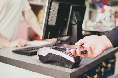 Alışverişçi akıllı telefon kullanarak ödeme yapar. İnsan yaşamında Nfc teknolojisi