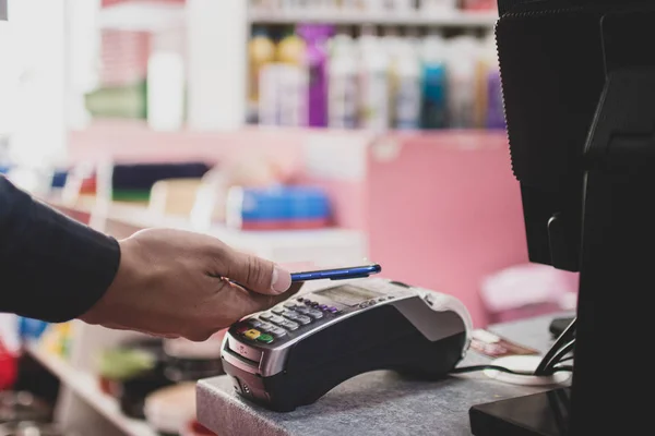 Shopper hace el pago con el teléfono inteligente. Tecnología NFC en la vida de las personas —  Fotos de Stock