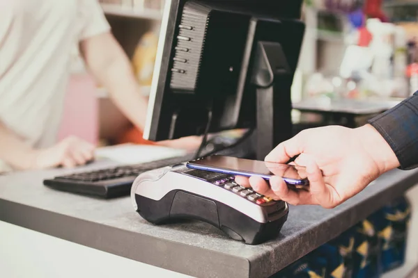 Shopper doet betaling met behulp van smartphone. NFC-Technologie in het leven van mensen — Stockfoto