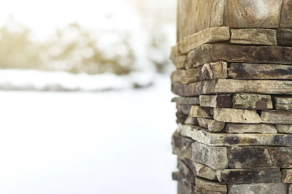 Formgivningsmall för gratulationskort på vintern tema, är kolumn uppbyggd av stenar i förgrunden, snö miljö på bakgrunden, utrymme för text, vykort, solljus, vinter skönhet — Stockfoto