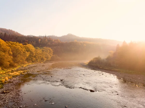 Чудовий осінній ранок у мальовничих Карпатах. М'яке сонячне світло пробуджує природу від сну. Світлий туман простягається над річкою. — стокове фото
