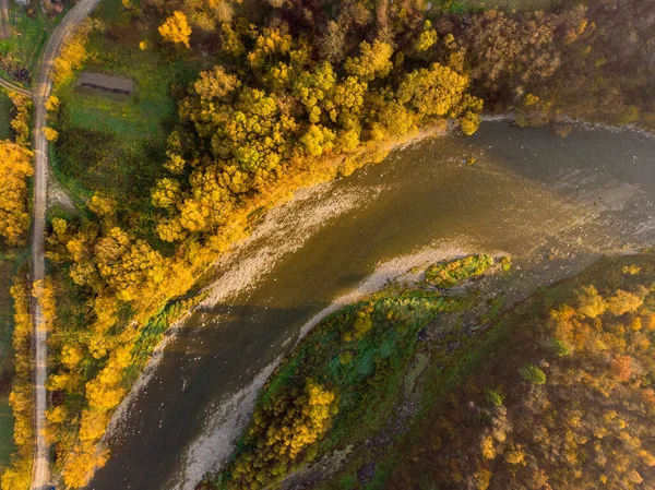 Над гірською річкою і різнокольоровими деревами. Золота природа в осінній час. Повітряний безпілотник вид зверху, накладний постріл — стокове фото