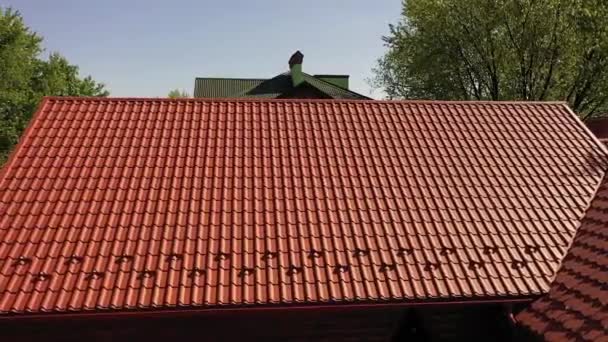 屋顶上覆盖着时尚和耐用的红色轻便金属屋面或金属砖 用金属砖覆盖屋顶的专业服务 — 图库视频影像