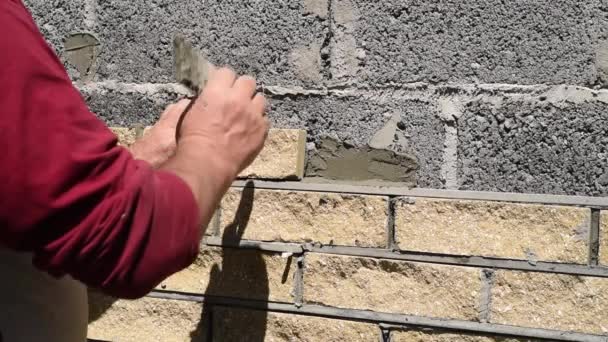 Adam Dekoratif Tuğlalarla Duvarın Cephesini Süslüyor Manzarayı Kapatıyor Yapıların Duvarlarını — Stok video