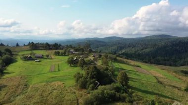 Ormanlar ve dağların arasındaki eski köyün insansız hava aracı görüntüsü. Güneşli bir günde pitoresk manzara