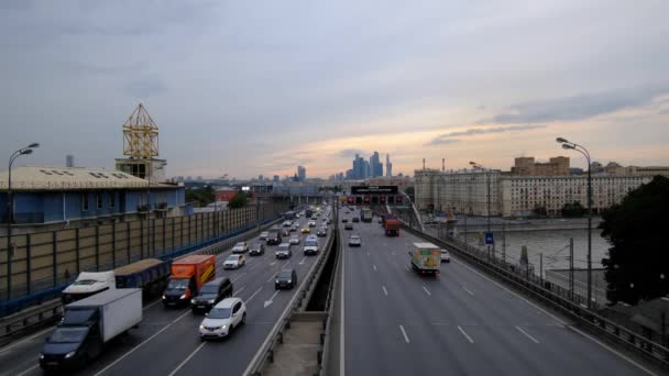 Mosca, Russia - agosto 2019: Auto in un denso ruscello sul ponte sullo sfondo della città serale — Video Stock