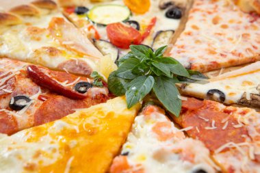 Fesleğen ile dekore edilmiş farklı malzemelerle pizza yakın çekim çeşitleri