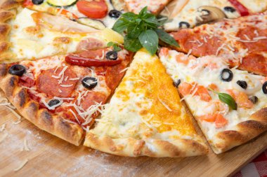Fesleğen ile dekore edilmiş farklı malzemelerle pizza yakın çekim çeşitleri