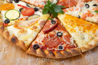 Fesleğen ile dekore edilmiş farklı malzemelerle pizza yakın çekim çeşitleri