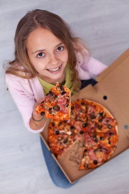O tutar olarak bir dilim, üstten görünüm gülümseyen bir kutu - pizza ile katta oturan genç Genç kız