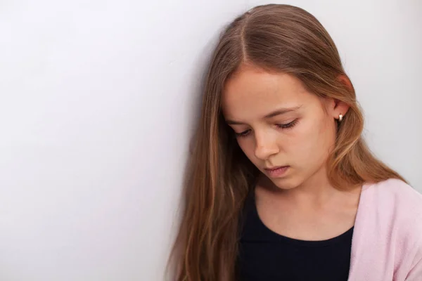Sad Teenager Girl Standing White Wall Downcast Eyes Thinking Abot — Stock Photo, Image