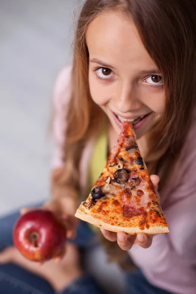 ピザのスライスが後のアップルを維持し 上面図 クローズ アップのかみ傷を取ることを探している若い女の子 — ストック写真